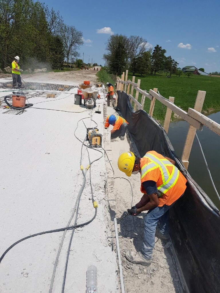 Chipping away bad concrete on a bridge deck in MItchell